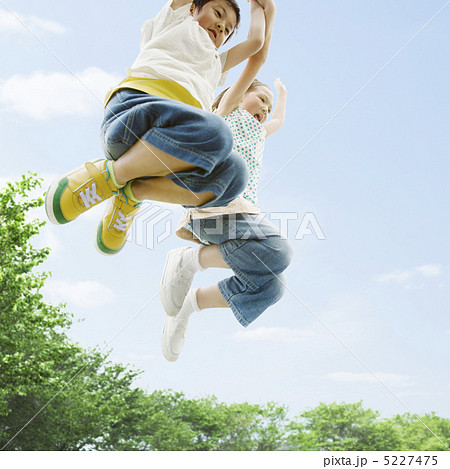 手をつないでジャンプする男の子と女の子 5227475