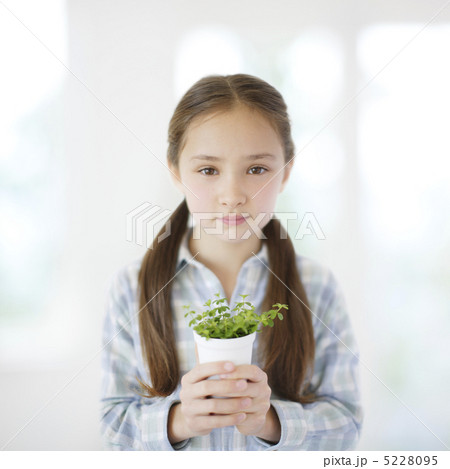 小さな植木鉢を持ち正面を見つめる少女 小さな植木鉢を持ち正面を見つめる少女 5228095