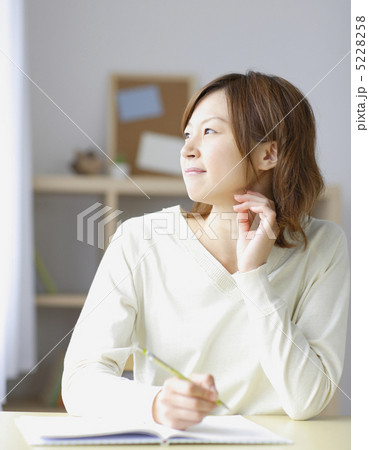 外を見つめながらペンを執る女性 外を見つめながらペンを執る女性 5228258