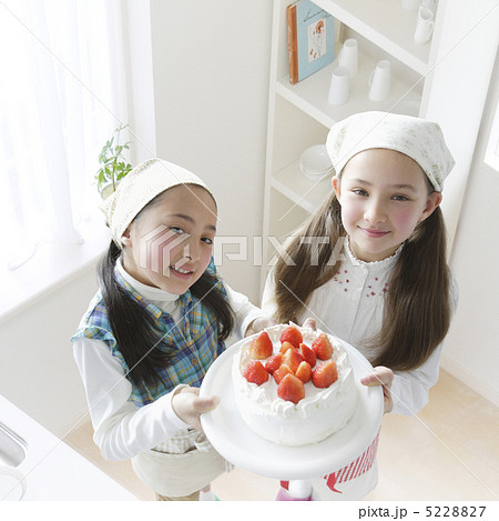 出来上がったケーキを自慢する二人の少女 5228827