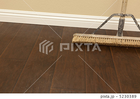 Push Broom on a Newly Installed Laminate Floor and Baseboard 5230389
