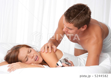 Young man waking up woman in white bed 5244582