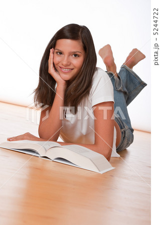 Happy teenager lying down with book 5244722