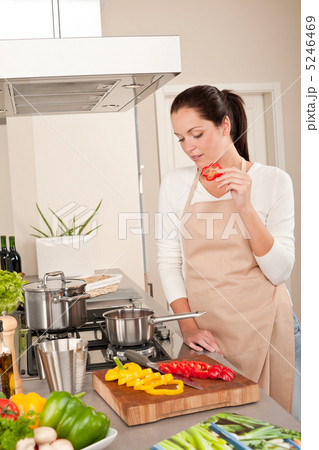 Happy woman biting red pepper in modern kitchen Happy woman biting red pepper in modern kitchen 5246469