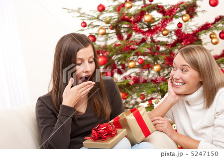 Two women unpacking Christmas present Two women unpacking Christmas present 5247150