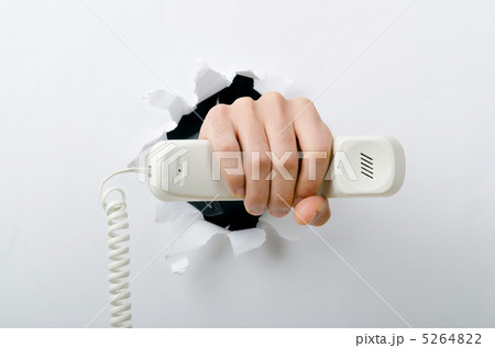 Hand holding phone through hole in paper Hand holding phone through hole in paper 5264822