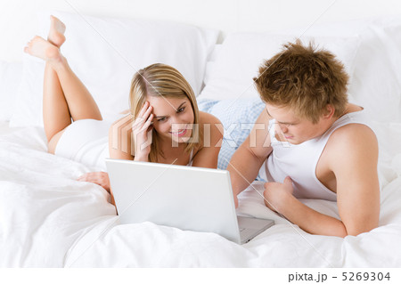 Young couple relax in bed with laptop 5269304