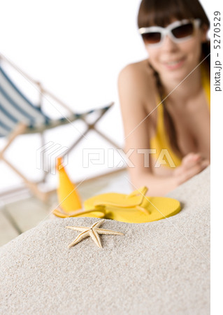 Beach - starfish on sand, woman in bikini in background Beach - starfish on sand, woman in bikini in background 5270529