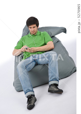 Young man with ear buds listening to music Young man with ear buds listening to music 5270965
