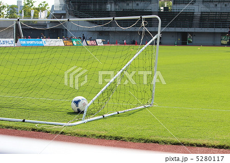 天然芝のグラウンドに置かれたサッカーボールとゴールの写真素材