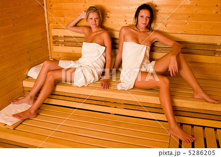 Sauna two women relaxing sitting wrapped towel 5286205