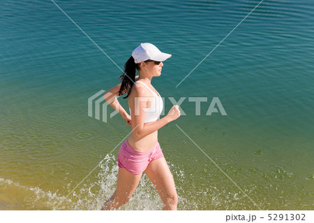 Summer sport fit woman jogging along seashore Summer sport fit woman jogging along seashore 5291302