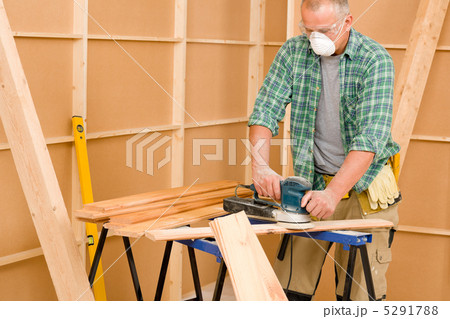 Handyman sanding wooden board diy home renovation 5291788