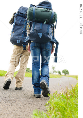 Hiking couple legs backpack on asphalt road 5291790