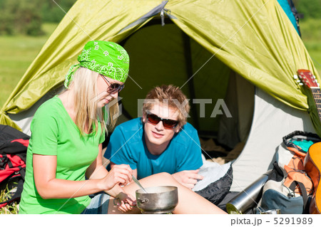 Young camping couple cooking meal outside tent 5291989