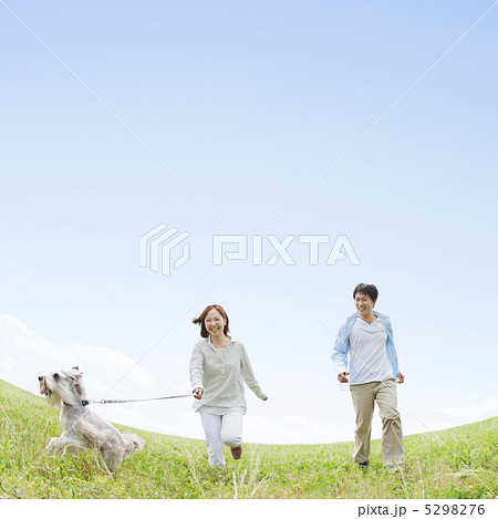 草原で犬と散歩をする日本人夫婦 5298276