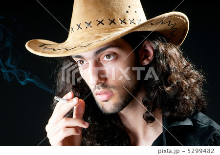 Man in cowbow hat smoking 5299482
