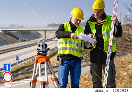 Geodesist read plans on construction site 5299933