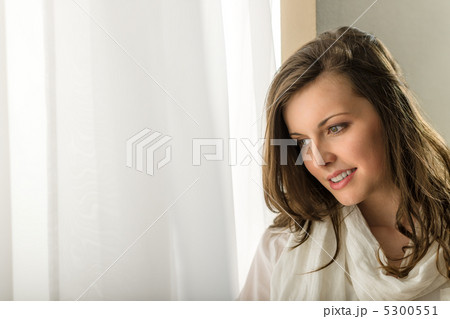 Thoughtful brunette woman looking out of window Thoughtful brunette woman looking out of window 5300551