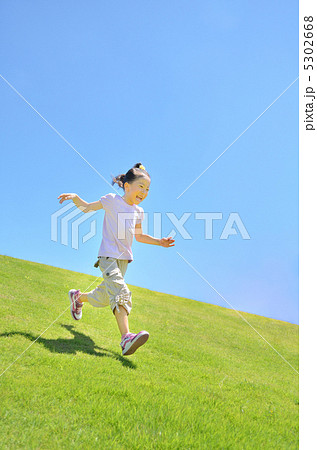 芝生を駆け下りる女の子（青空） 5302668