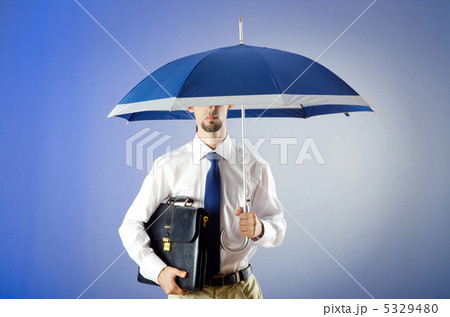 Businessman holding umbrella in the office Businessman holding umbrella in the office 5329480