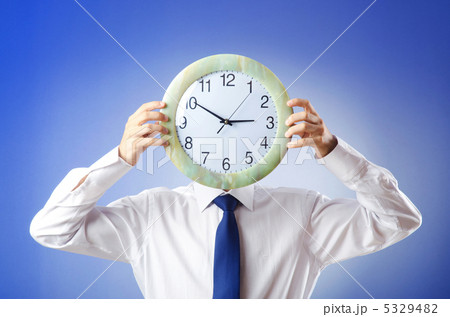 Businessman covering his face with clock Businessman covering his face with clock 5329482