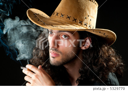 Man in cowbow hat smoking 5329770