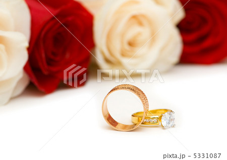 Golden rings and roses isolated on the white 5331087