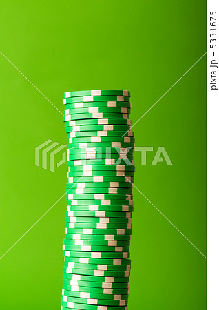 Stack of red casino chips against green background 5331675