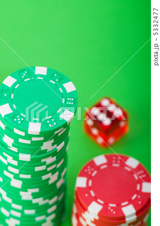 Casino chips and dice against green background 5332477