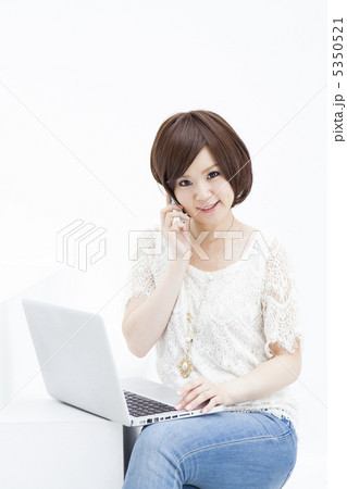 パソコンを見ながら電話する女性 5350521
