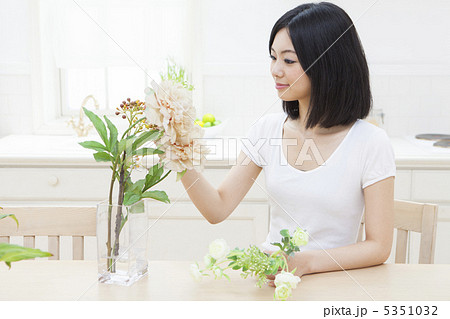 花瓶に花を生ける女性の写真素材