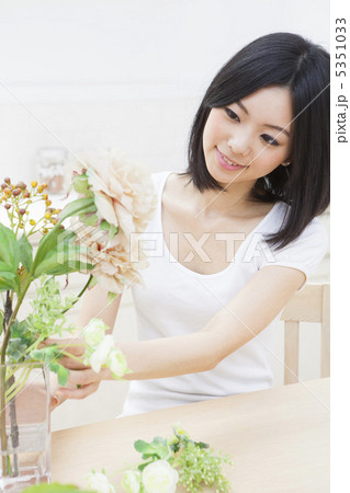 花瓶に花を生ける女性の写真素材