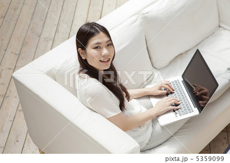 白いソファでノートパソコンを操作する女性 5359099