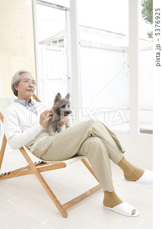 犬を抱いてイスに座るシニア男性 犬を抱いてイスに座るシニア男性 5376925