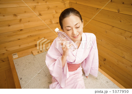岩盤浴後にペットボトルを頬につける女性 5377950