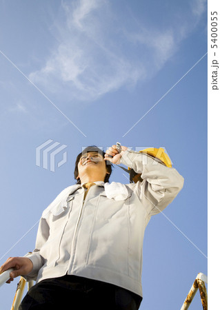 ヘルメットを肩に担ぐビジネスマンの写真素材