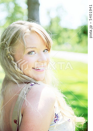 肩越しにこちらに微笑みかける金髪外国人女性の写真素材