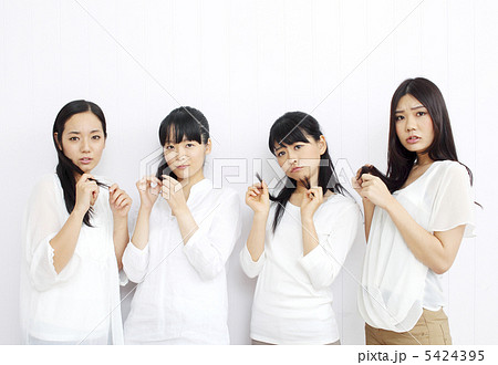 痛んだ髪の毛を気にする女性四人組 5424395