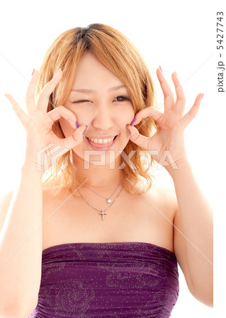 両手でokサインしながら舌を出すドレスの女性の写真素材