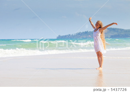 Happy girl with long hair in white dress on sea beach 5437726