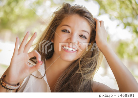 Attractive Mixed Race Girl Portrait with Okay Hand Sign Outdoors 5468891