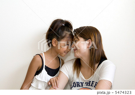 おでこをくっつける女の子とママの写真素材