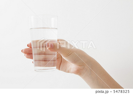 水の入ったコップを持つ手の写真素材