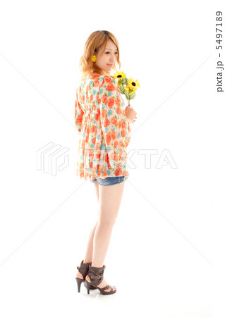 花を持って後ろを振り向く可愛い女の子の写真素材