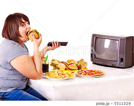 Woman eating fast food and watching TV. Woman eating fast food and watching TV. 5511329