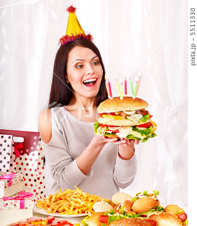 Woman eating hamburger at birthday. Woman eating hamburger at birthday. 5511330