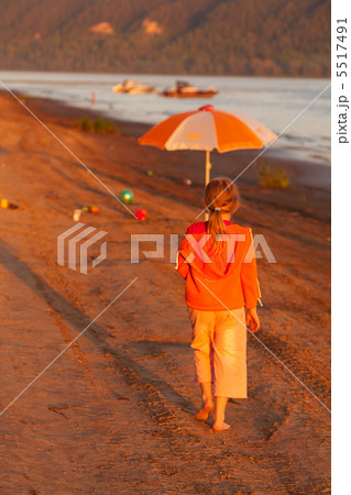 little girl running along the beach in the sunshine 5517491