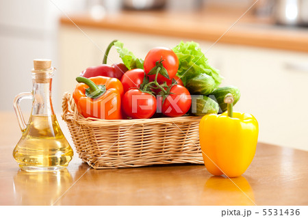 Healthy food fresh vegetables in basket and bottle with oil on t 5531436