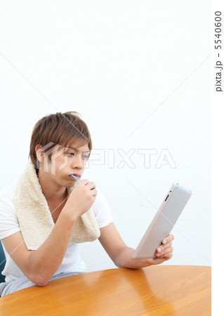 歯を磨きながらタブレットを使う男性 歯を磨きながらタブレットを使う男性 5540600